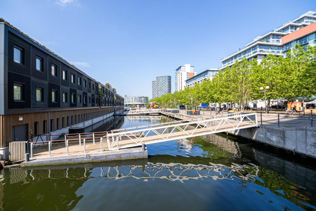 eine Brücke über einen Fluss in einer Stadt mit Gebäuden in der Unterkunft EXCEL LONDON MAJESTIC APARTMENT in London