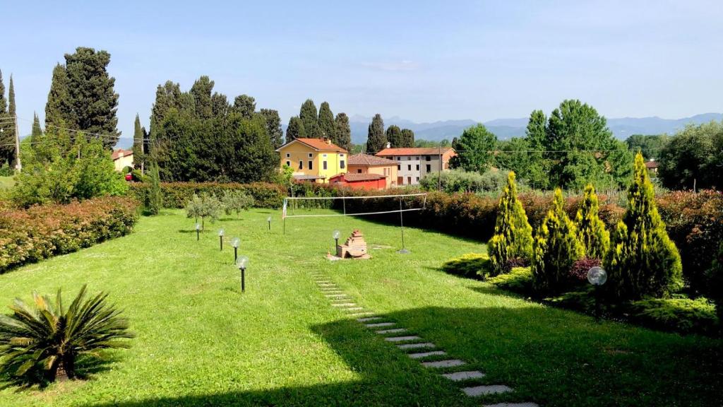 une femme assise sur une pelouse dans un jardin dans l'établissement Intero alloggio campagna Lucca, à Capannori