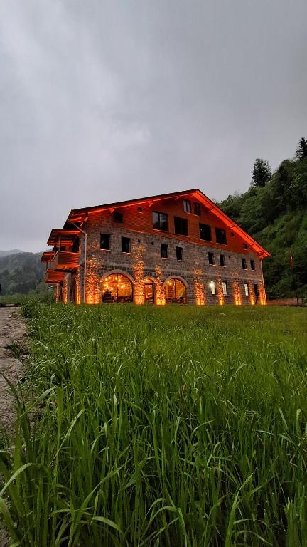 a barn with its lights on in a field at Hemşin Ata Konağım in Çamlıhemşin