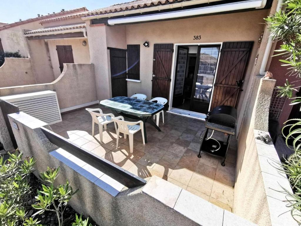 un patio avec une table, des chaises et un barbecue dans l'établissement Résidence Grande Bleue - VILLA 3 MEZZANINE PIECES 6 couchages PORT LEUCATE. Réf: 3GB_383 MAE-7101, à Leucate