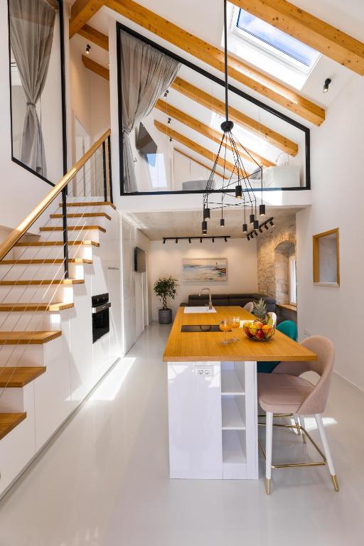 a kitchen and dining room with a table and stairs at Apartment Nezi in Pučišća