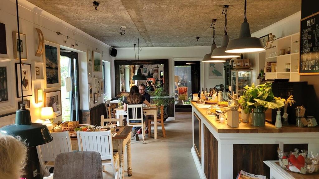 un restaurante con bar y gente sentada en las mesas en Przechowalnia Marzeń- Adults Only, en Mikołajki