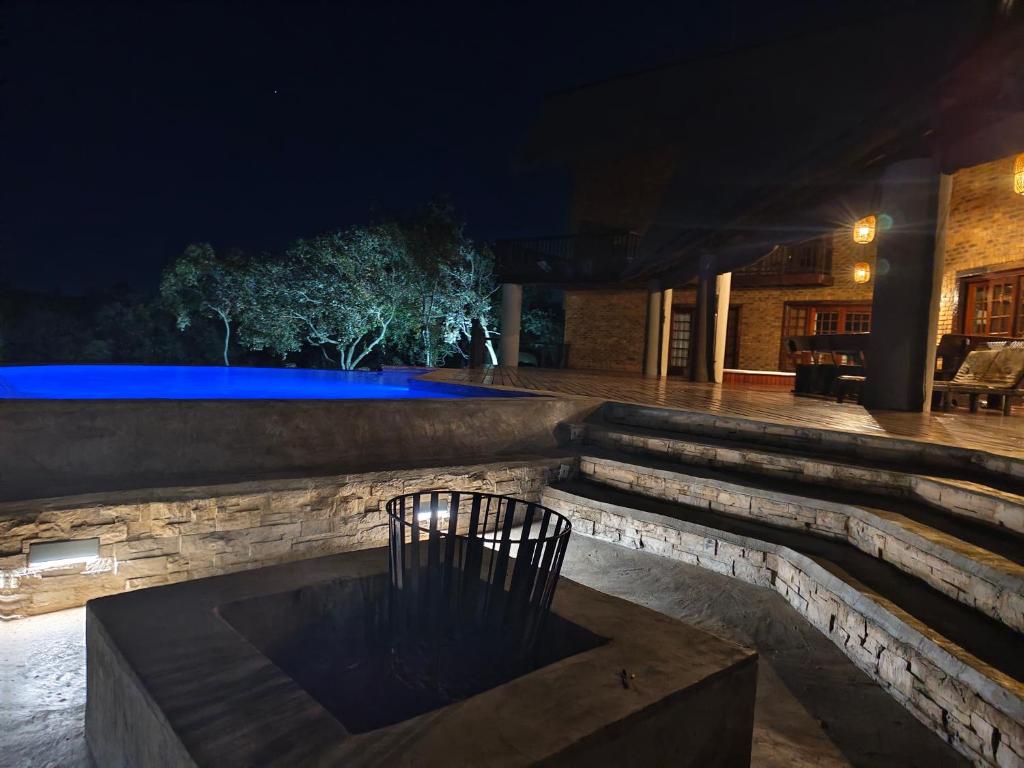 a patio at night with a bench in the middle at Tholo Private Game Lodge in Bela-Bela