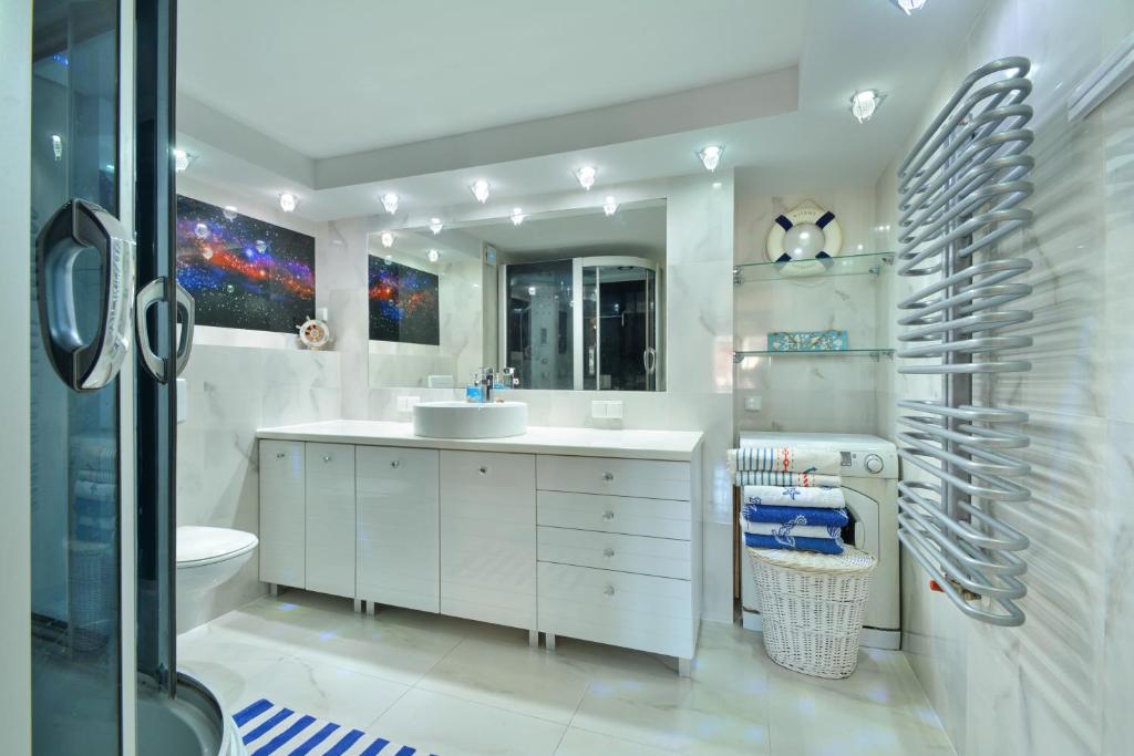 ジビジノにあるMuszelka pokoje i apartamentyの白いバスルーム(洗面台、トイレ付)
