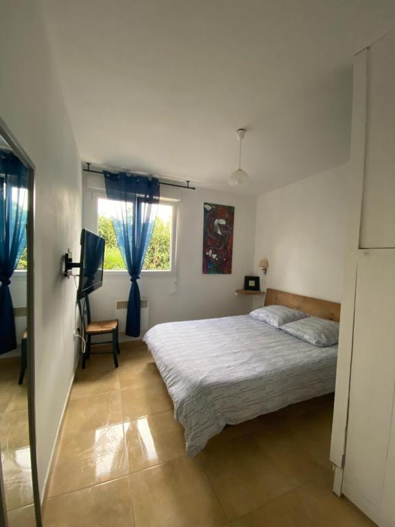 une chambre avec un grand lit et une fenêtre dans l'établissement Terre et mer, à Urrugne
