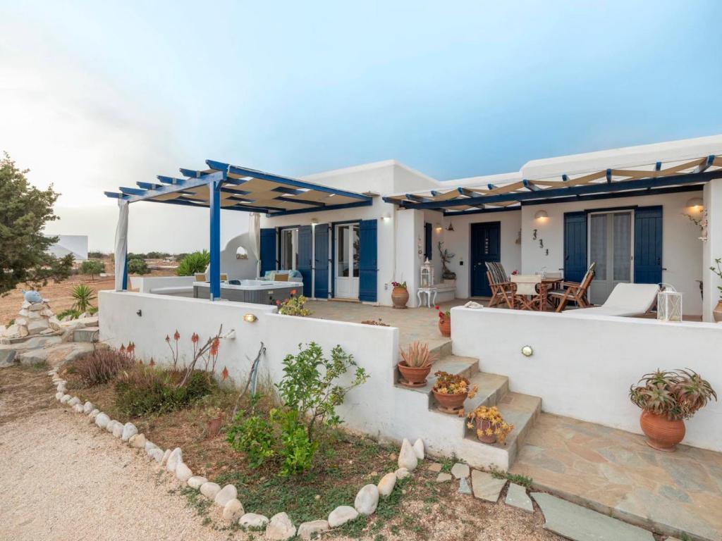 uma casa com uma parede branca e um pátio em Cycladic home in Paros em Kampos Paros