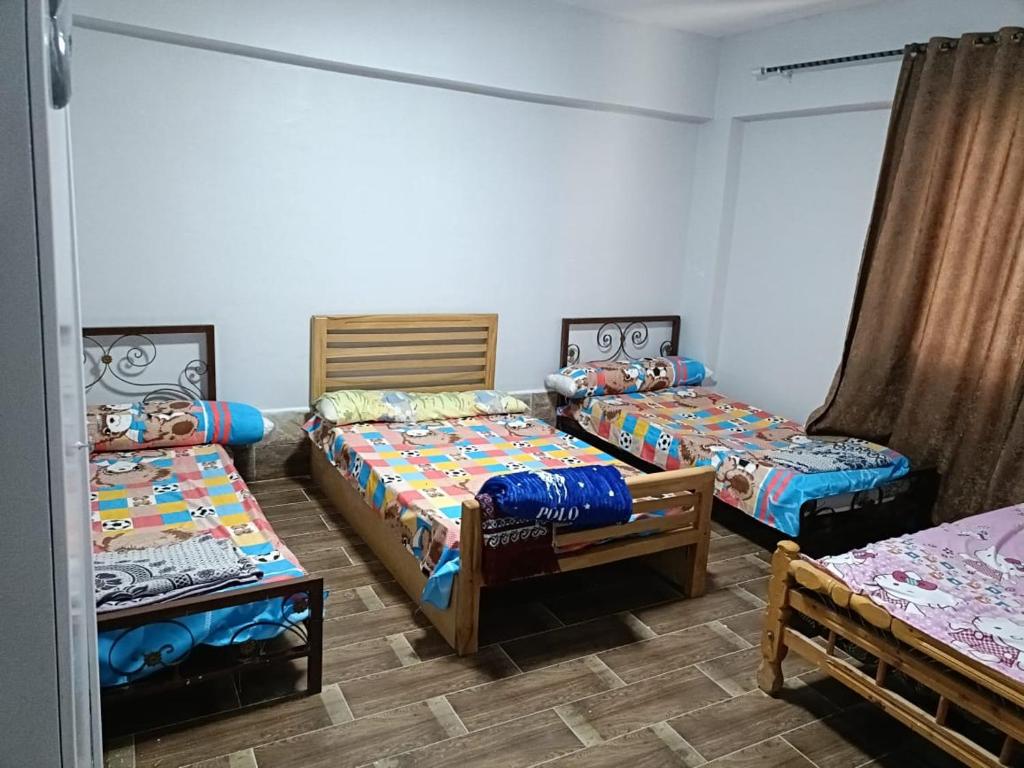 a room with three beds in a room at إطلالة مباشرة على البحر شاليه فندقي مكيف بحديقة خاصة راس سدر in Ras Sedr