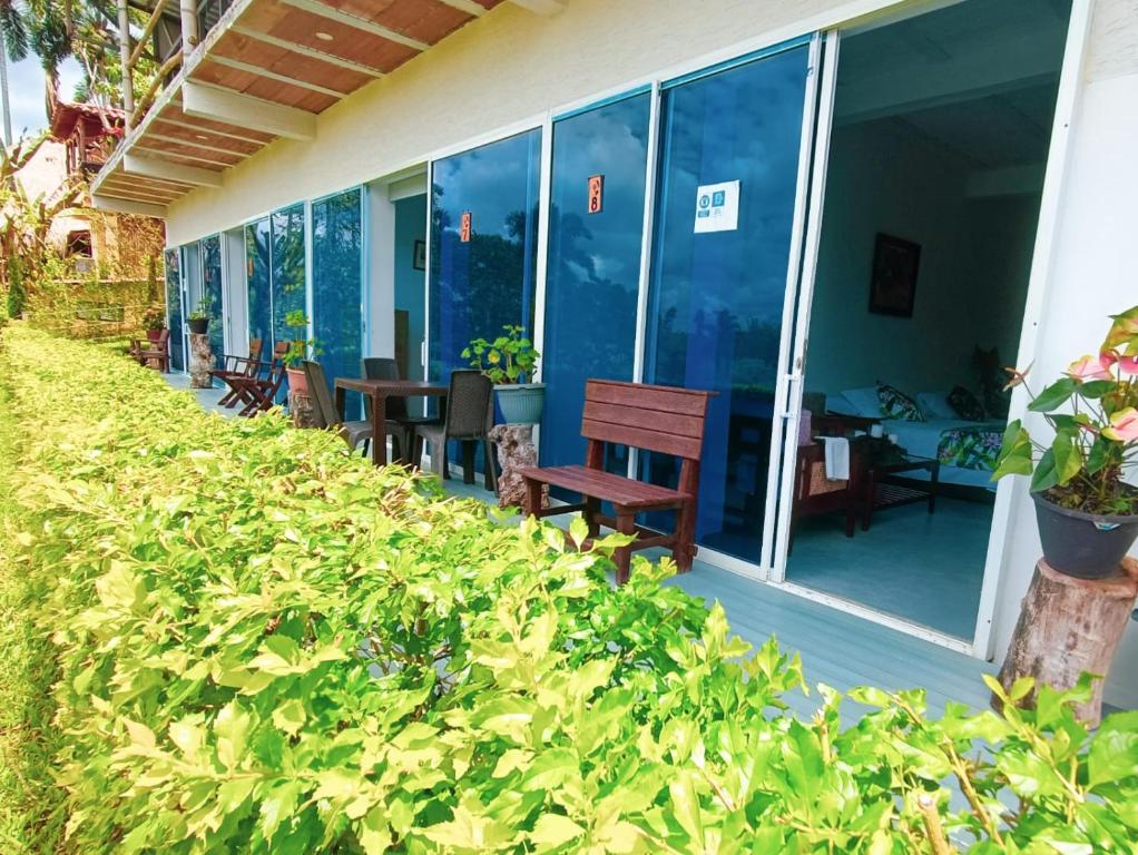 un patio con sillas, mesas y ventanas en Hotel del Campo, en Quimbaya