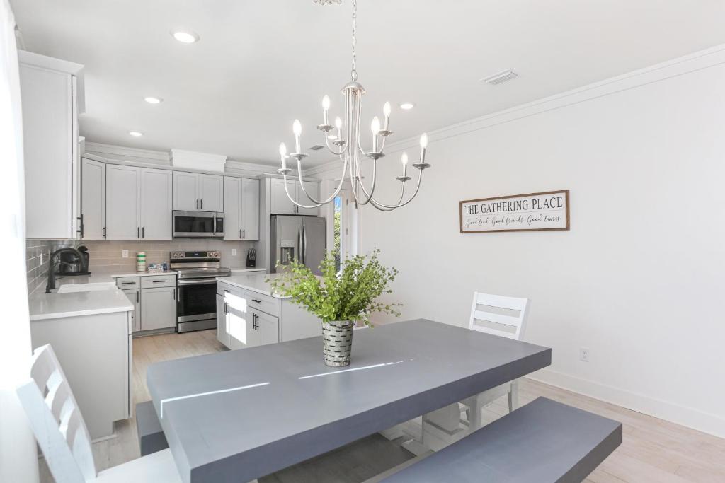 a white kitchen with a table and a vase on it at Keys to the Cape by Pristine Properties Vacation Rentals in Cape San Blas