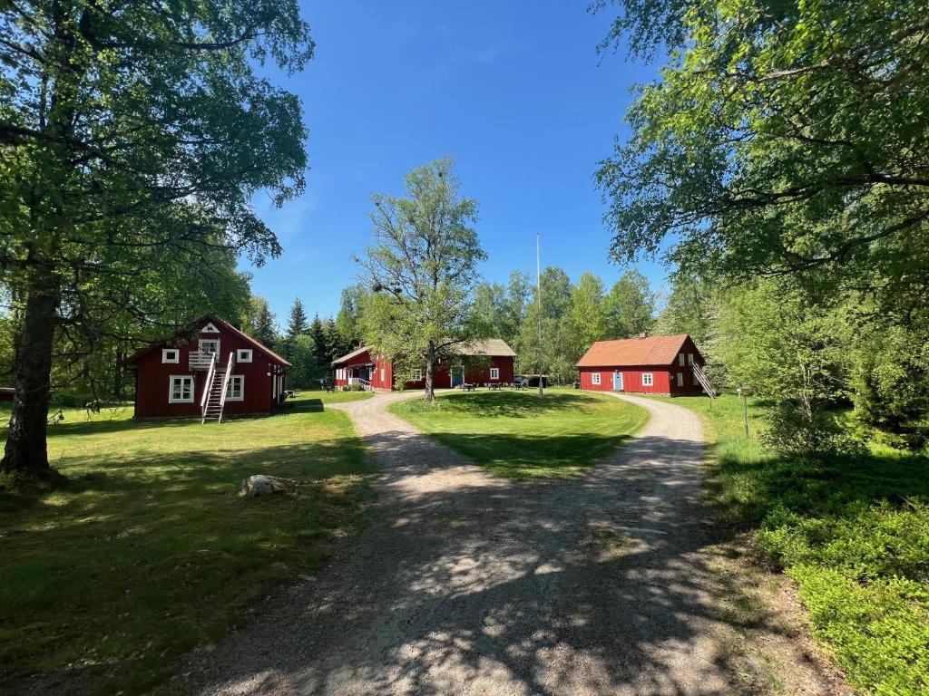 uma estrada de terra que leva a dois celeiros vermelhos em Skagagården, Mossen em Undenäs