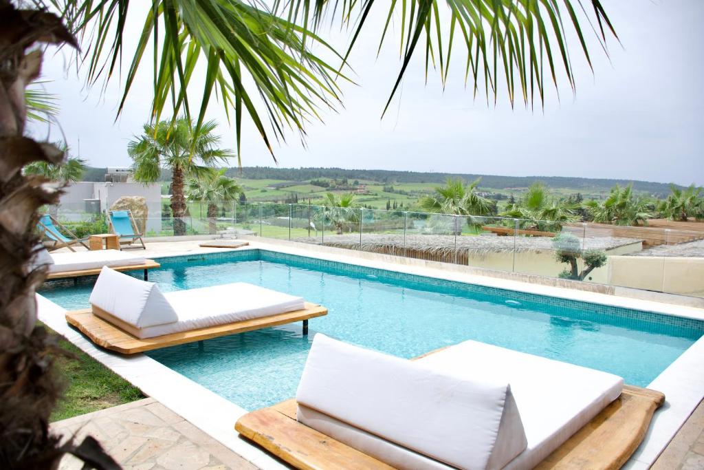 a swimming pool with two chaise lounge chairs and a resort at SANIMAR By Mono Alex in Kassandra