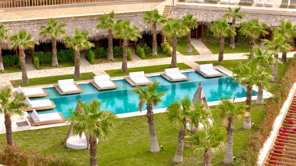 an overhead view of a resort pool with lounge chairs and palm trees at SANIMAR By Mono Alex in Kassandra