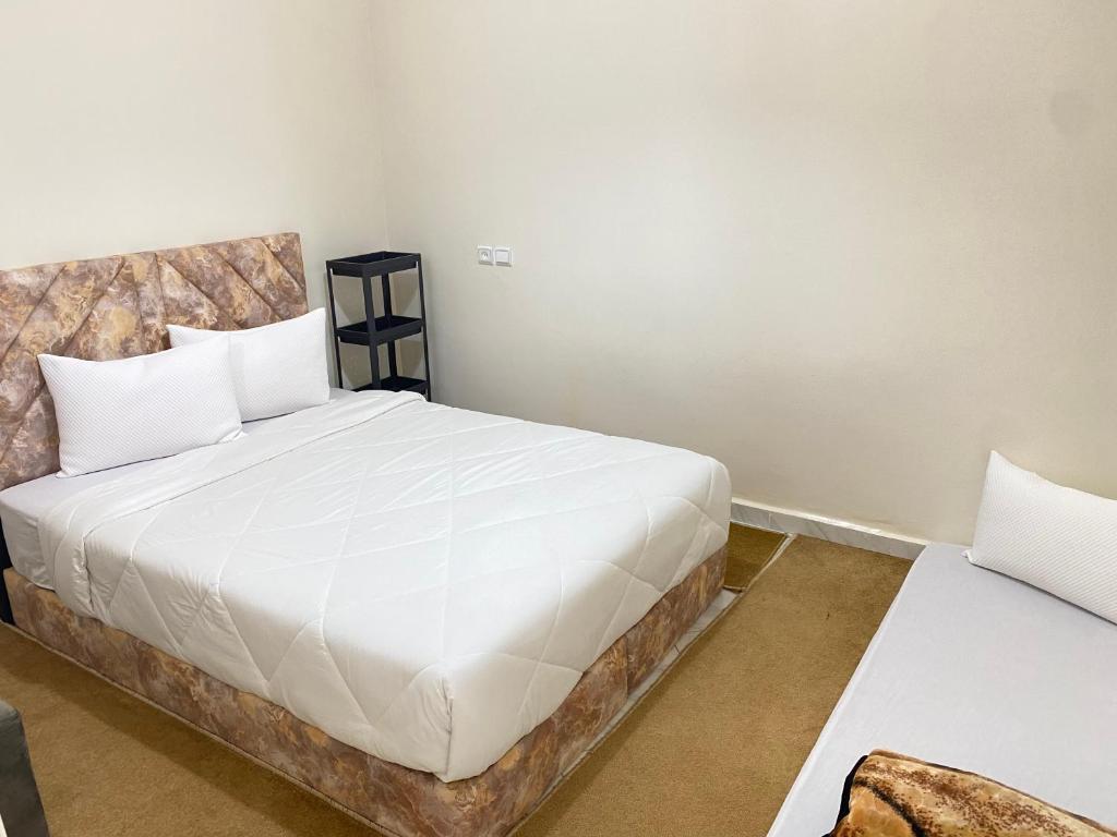 1 dormitorio con 1 cama grande con sábanas blancas en Dakhla sky blue en Dakhla