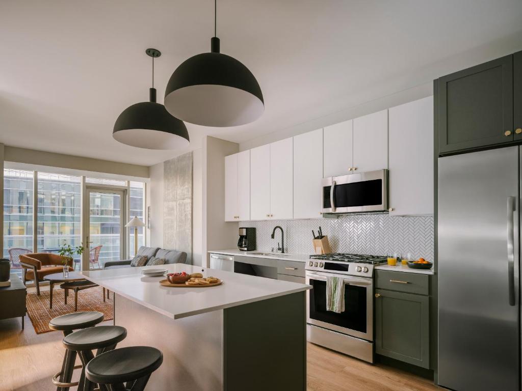 a kitchen with green cabinets and a white counter top at Sonder at North Loop Green in Minneapolis