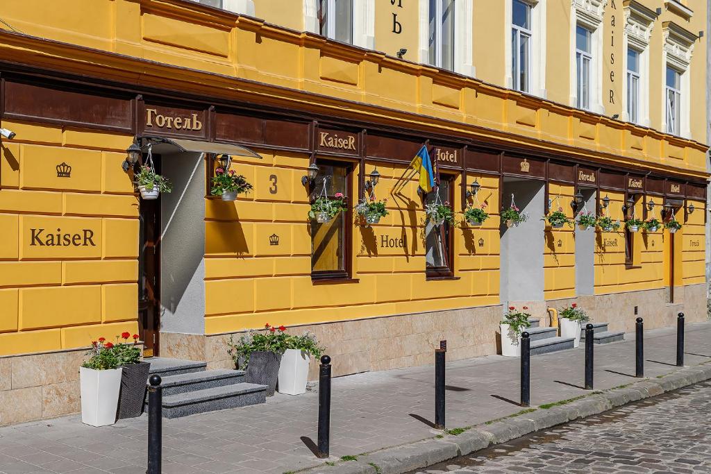 żółty budynek z doniczkami przed nim w obiekcie Готель Кайзер у Львові w Lwowie