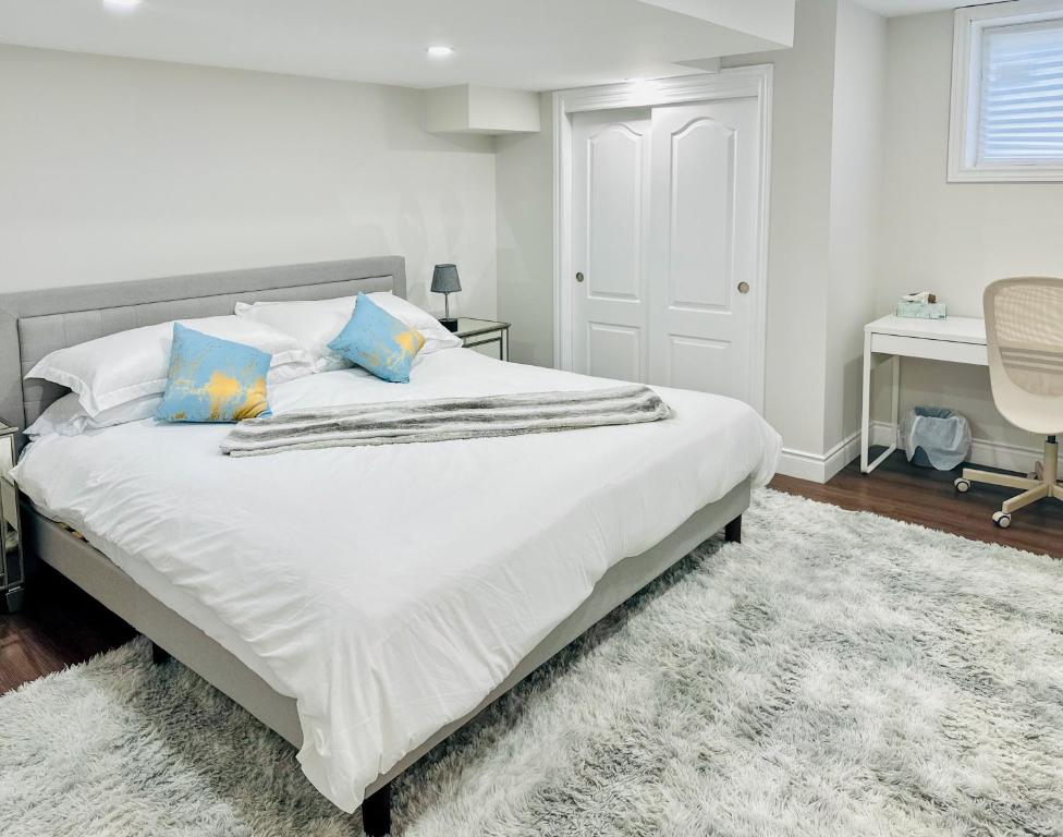 a bedroom with a large white bed with blue pillows at Spacious 2 Bedroom 1 bath Mississauga Basement Apartment in Mississauga