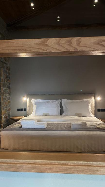 a bedroom with a large bed with white pillows at EJ Boutique Suites in Milina