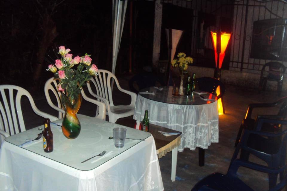 a table with a vase with flowers on it at CABAÑA LA HERRADURA LUZ ANGELA in Dibulla