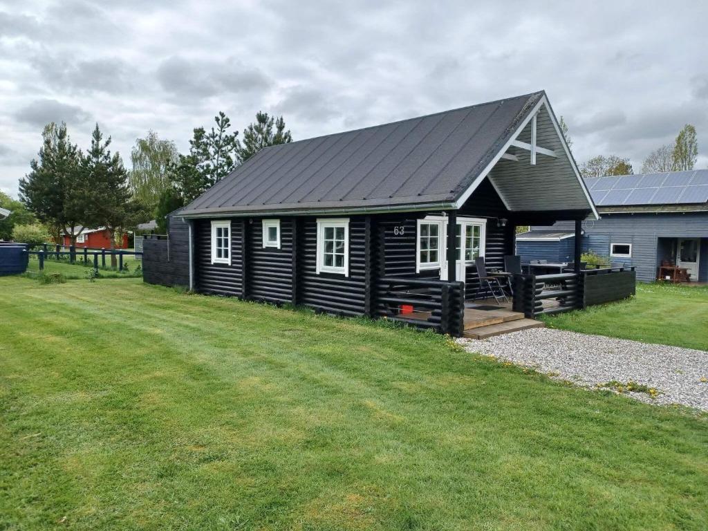 a black house with a large yard in front of it at 6 person holiday home in Hovborg-By Traum in Hovborg