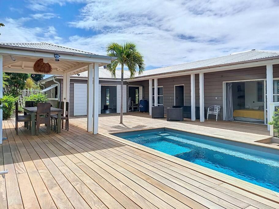 ein Haus mit einer Terrasse und einem Pool in der Unterkunft Villa vue mer et montagne Pelée in Le Carbet