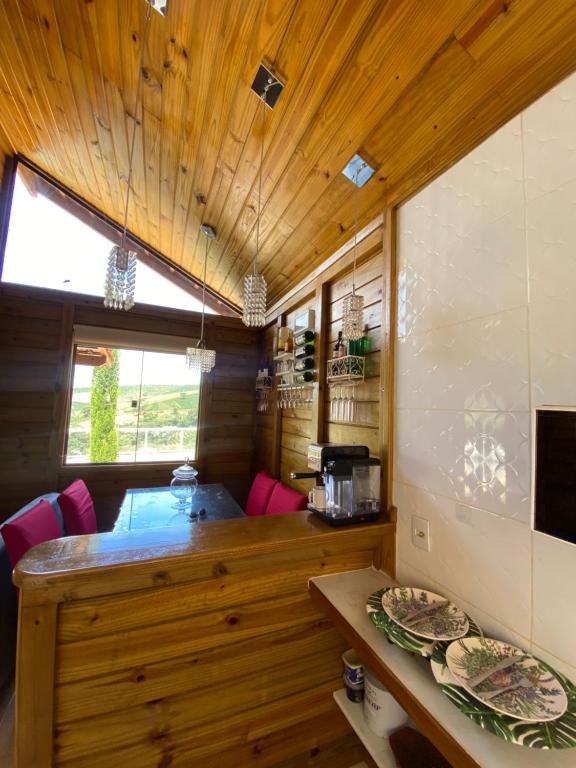 a kitchen with wooden ceilings and a counter with plates at chalecachoeiradochiador in Espera Feliz