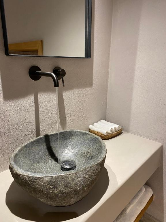 a bathroom with a stone sink on a counter at EJ Boutique Suites in Milina