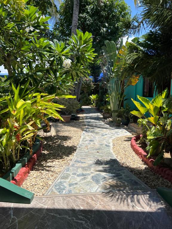 un chemin à travers un jardin planté de plantes et d'arbres dans l'établissement Bamboo Paradise Beach Resort, à Argao
