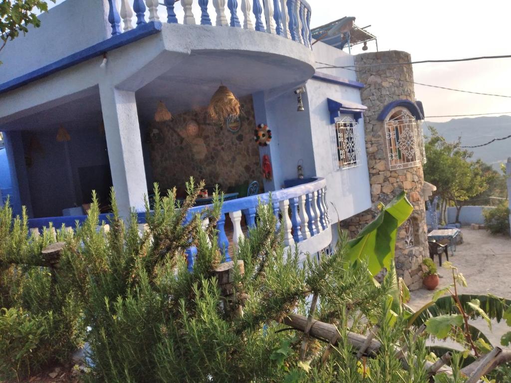 une maison bleue et blanche avec des arbres devant elle dans l'établissement Blue House Town, à Chefchaouen