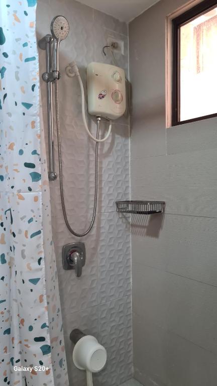 a shower with a shower head in a bathroom at One Oasis 2BR beside SM City Mall upto 6pax in Davao City