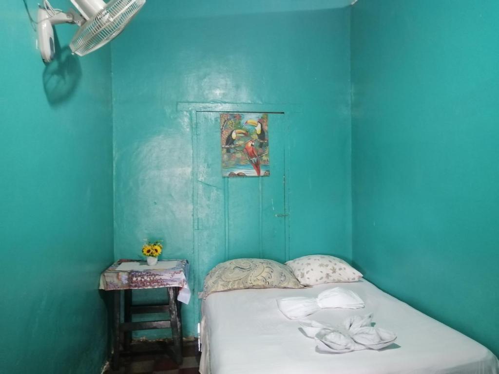 a blue room with a bed and a table at Hostal Gran Jade in Moyogalpa