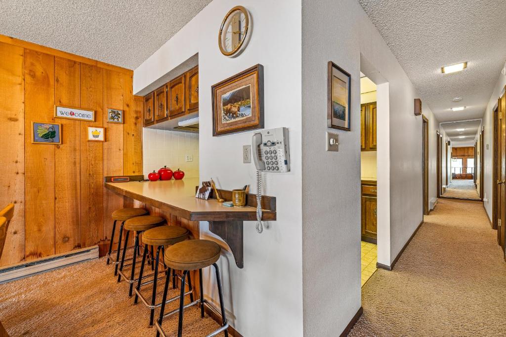 Una cocina con una barra con taburetes y un fregadero. en New* 70s Lakefront condo - dock - pool - beach -, en McCall