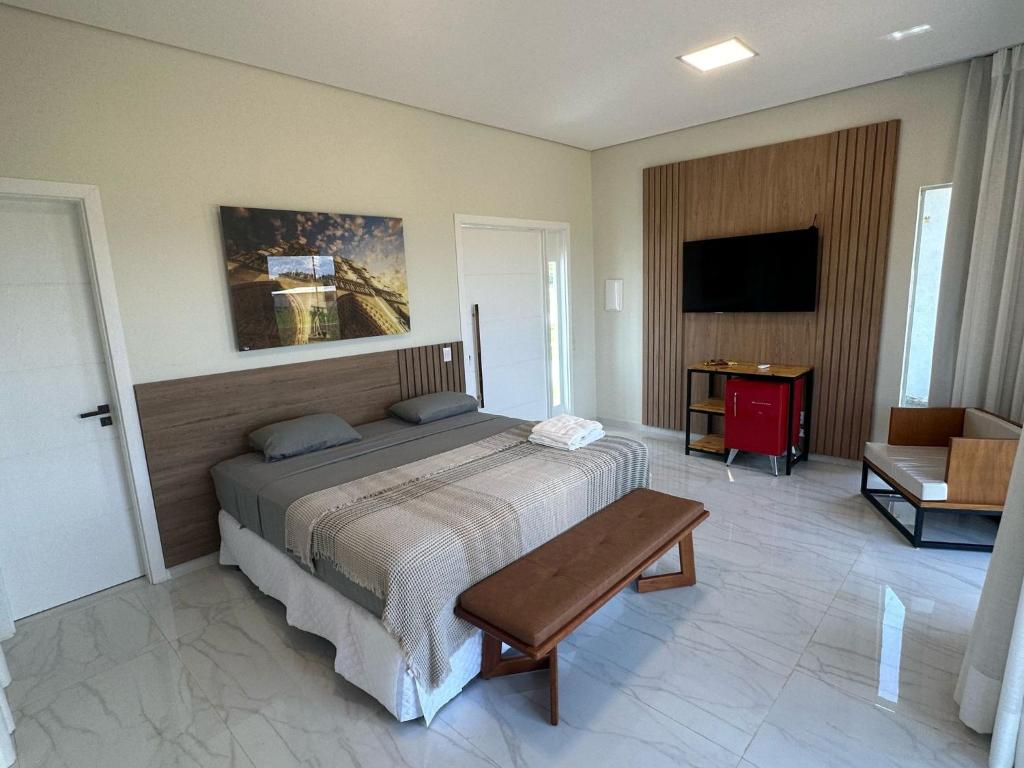 博阿維斯塔的住宿－Villa'S Roraima - Pousada & Natureza，一间卧室配有一张床、一张桌子和一台电视。