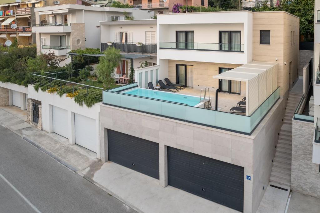 an apartment with a swimming pool on the roof of a building at Luxury villa with a swimming pool Makarska - 23218 in Makarska