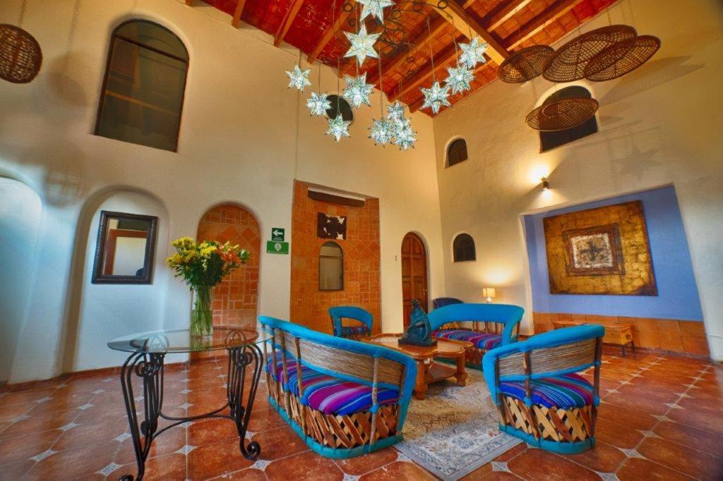 salon z niebieskimi krzesłami i szklanym stołem w obiekcie Hotel Casa Tequis San Luis Potosi w mieście San Luis Potosí