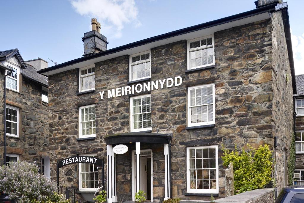 an old stone building with a sign on it at Y Meirionnydd Townhouse in Dolgellau