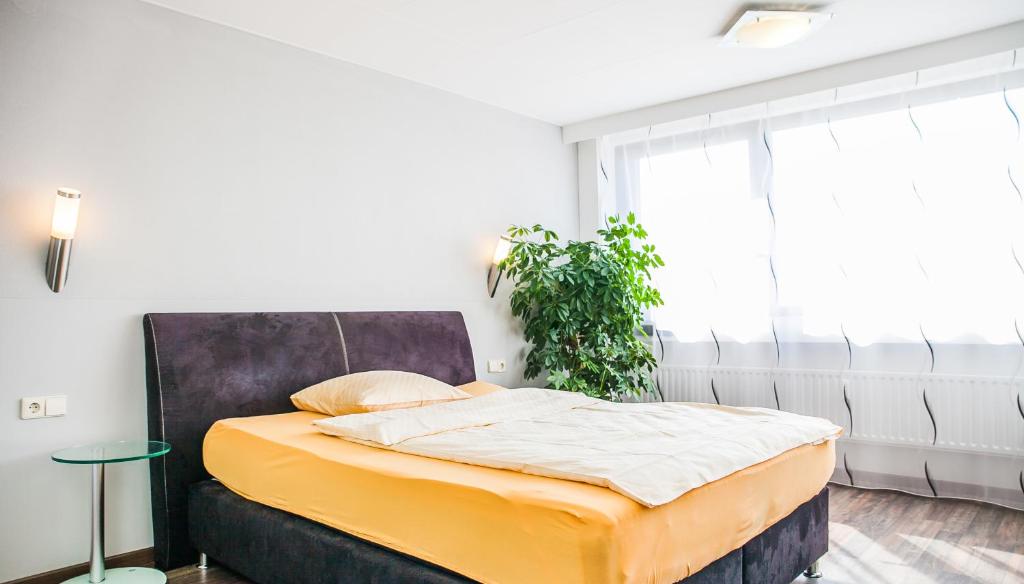 a bedroom with a bed and a plant at City Hotel Heilbronn in Heilbronn