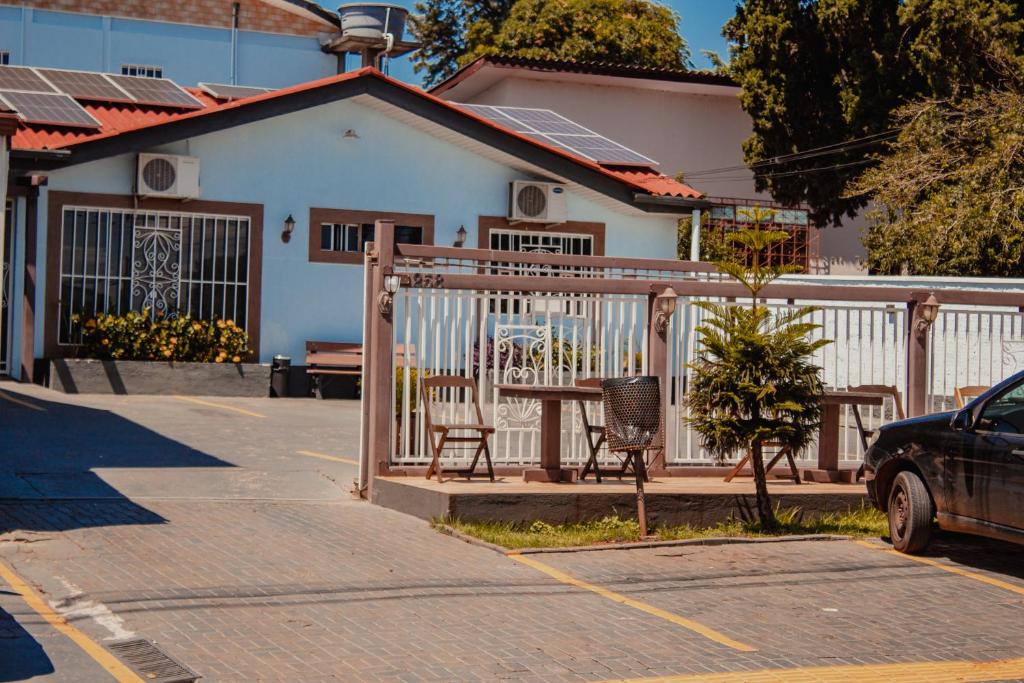 una mesa y sillas frente a una casa en Hotel e Pousada Caroline en Foz do Iguaçu