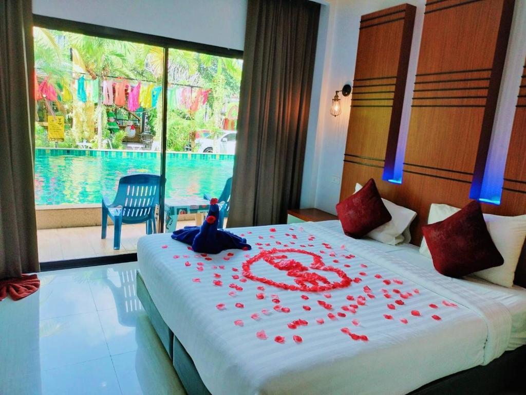 Un dormitorio con una cama con flores rojas. en Rimnatee Resort Trang, en Trang