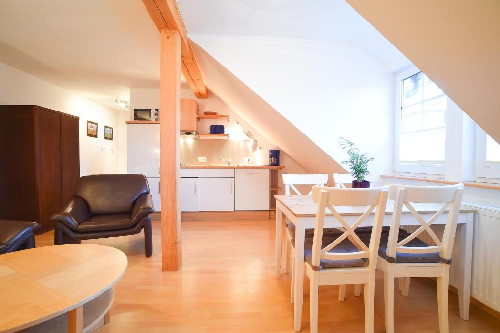 Una cocina y un comedor con mesa y sillas. en Hof Köhne - Altes Bauernhaus - Wohnung Dachstube links, en Schmallenberg