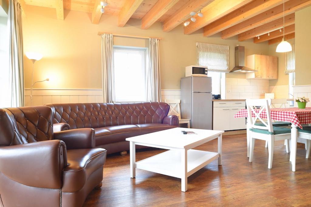 een woonkamer met een leren bank en een tafel bij Hof Köhne - Haus an der Weide rechts in Schmallenberg