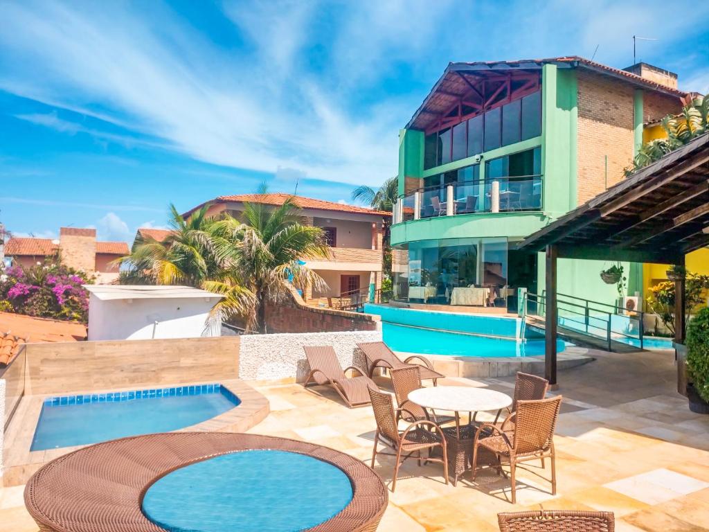 eine Terrasse mit einem Tisch und Stühlen neben einem Gebäude in der Unterkunft Planet Dunas Residence in Aquiraz