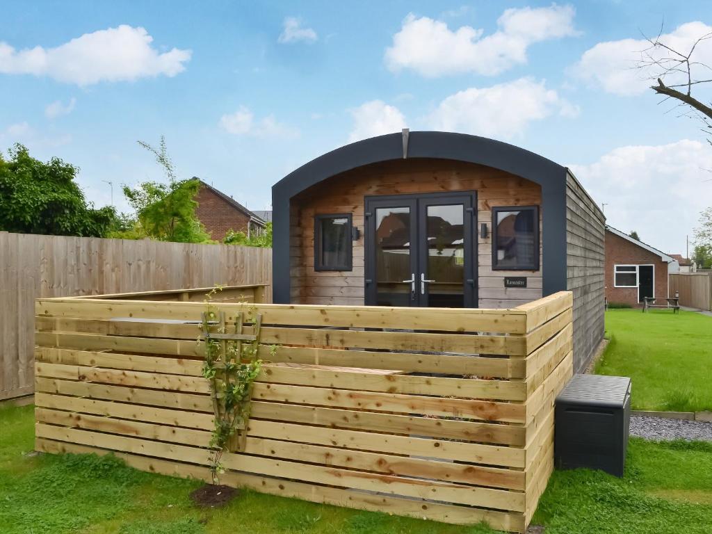 una casa pequeña con una valla de madera en un patio en Lancaster - Uk47054 en Holme upon Spalding Moor