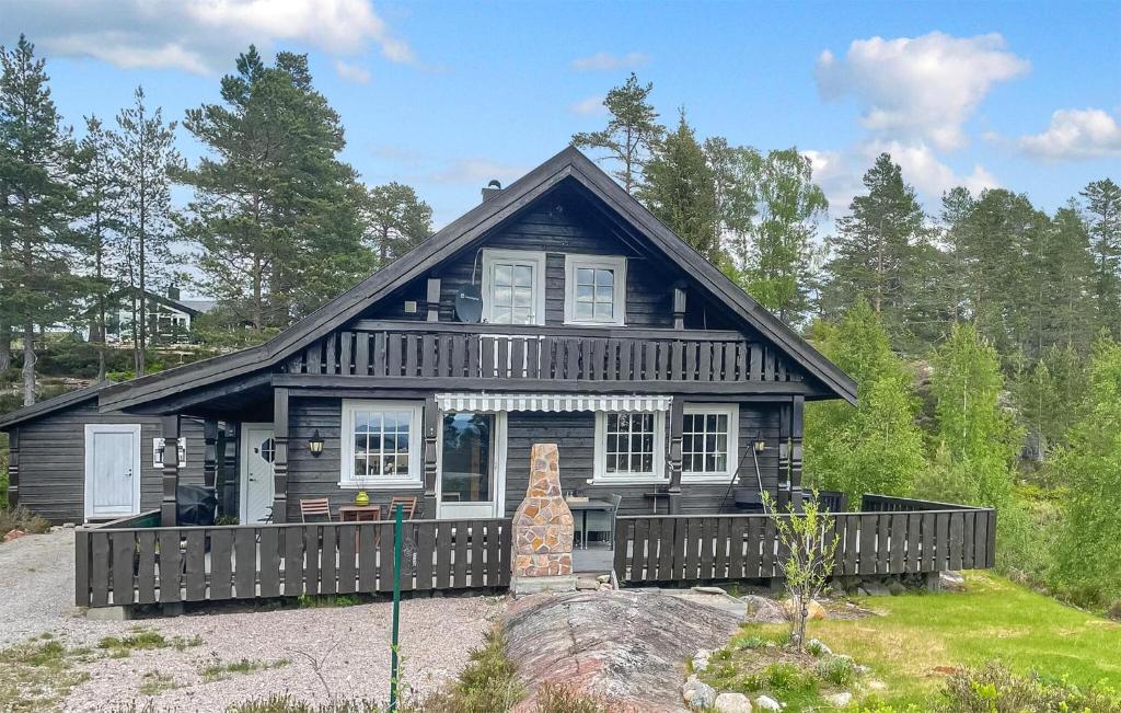 a black house with a fence in front of it at 3 Bedroom Gorgeous Home In Treungen in Treungen