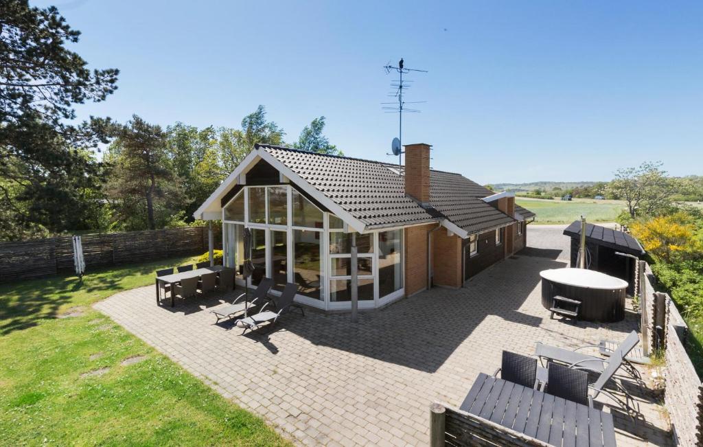 Casa con patio con mesa y sillas en Pet Friendly Home In Ebeltoft With House Sea View, en Femmøller