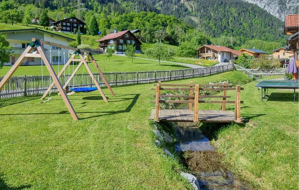 a wooden bridge over a river with a playground at Lovely Home In Dalaas With Kitchen in Dalaas