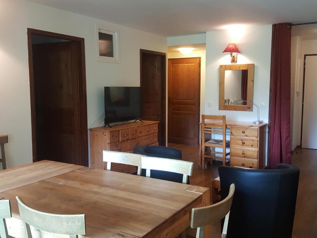 une salle à manger avec une table, des chaises et une télévision dans l'établissement Appartement cosy avec WiFi, parking et animaux admis à Brides-les-Bains - FR-1-512-9, à Brides-les-Bains