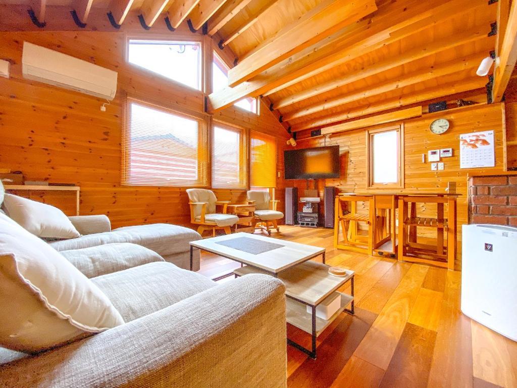 a living room with a couch and a tv at 「KIRAKU」Wood House稚内 in Wakkanai