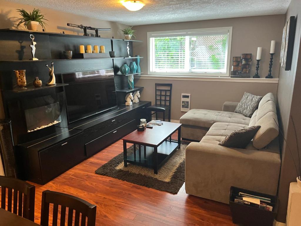 a living room with a couch and a fireplace at Cozy and modern 3 bedroom in central location! in Victoria