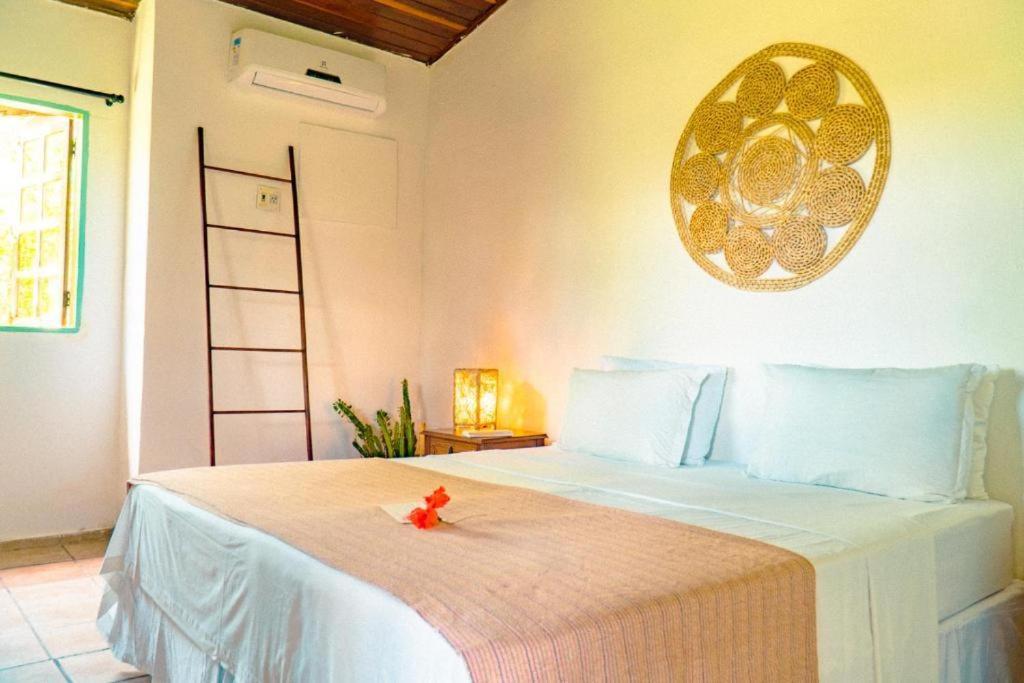um quarto com uma cama com uma flor vermelha em Pousada Sossego em Pipa