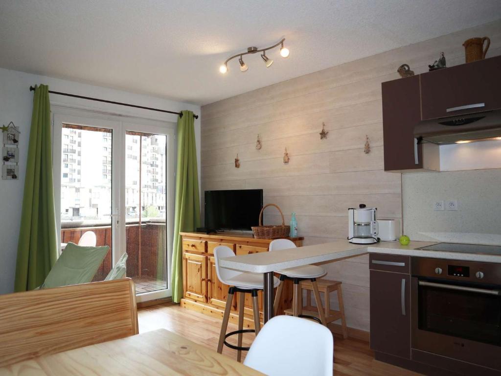 une cuisine avec une table et des chaises dans une pièce dans l'établissement Studio spacieux 4 pers aux Orres, skis aux pieds - FR-1-322-606, aux Orres